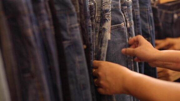 女人在商店里挑选牛仔裤的手被剪短了