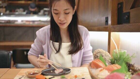 朋友在日本餐厅用餐餐厅的餐桌上摆满了各式各样的寿司、海鲜、牡蛎、生鱼片