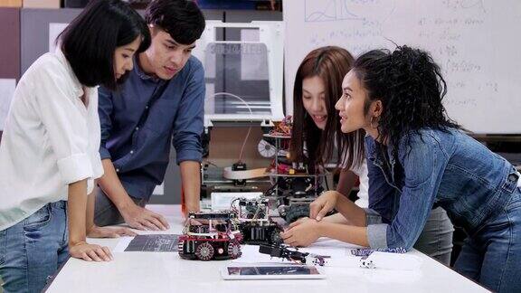 青少年工作在一个全功能的可编程机器人俱乐部项目创意设计师在车间测试机器人原型科学概念