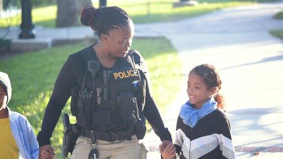 社区里的女警察带着两个孩子散步
