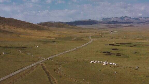 俯瞰风景优美的荒野蒙古包营地和吉尔吉斯斯坦松吉湖的公路