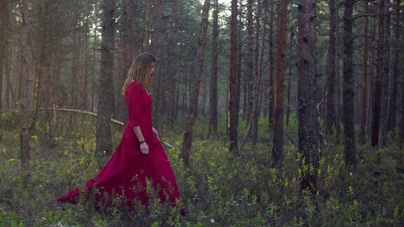 穿着红衣服的年轻女子在森林里散步