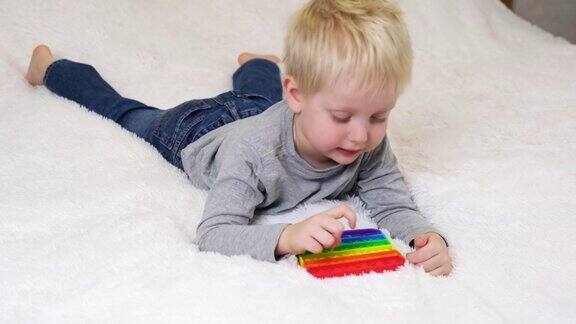 小男孩撒谎玩一个教育游戏彩色的抗压力感觉玩具坐立不安把它放在孩子的手里抗压力潮流流行它玩具彩虹感觉烦躁不安时尚硅胶玩具