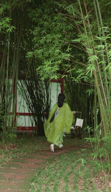 一位身着汉服的美丽女子走在竹径上