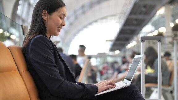 一名女子在机场使用笔记本电脑