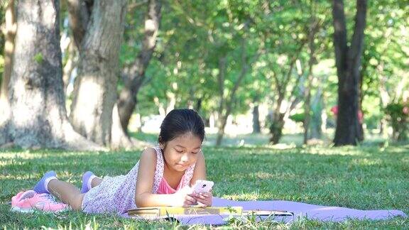 小女孩在公园里玩手机