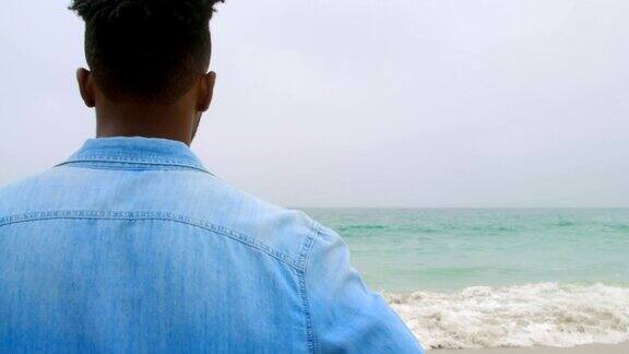 非裔美国人站在沙滩上的后视镜4k