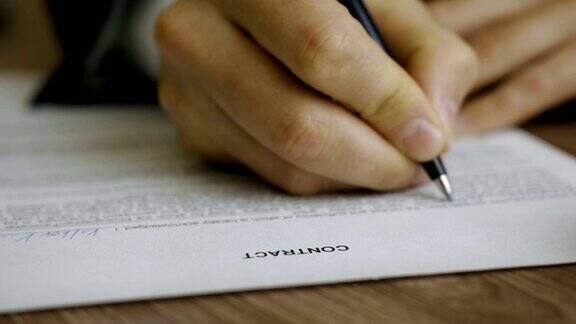 商人签商务合同协议男手捂着笔写签名这个人修改并填写了文件