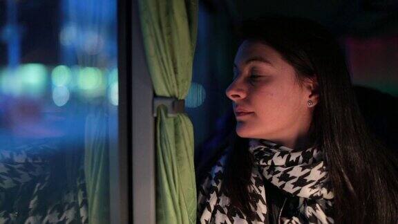 一个晚上从公交车车窗往外看的女人