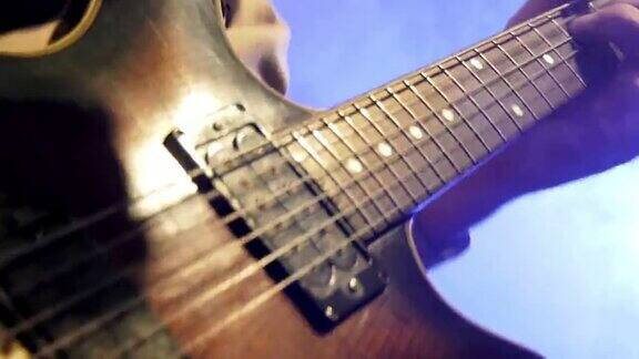 吉他手在明亮闪烁的灯光下演奏电吉他手吉他指板和弦乐特写
