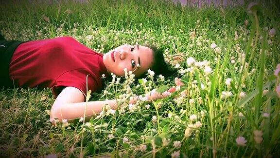 年轻的亚洲女子躺在草地上动作缓慢