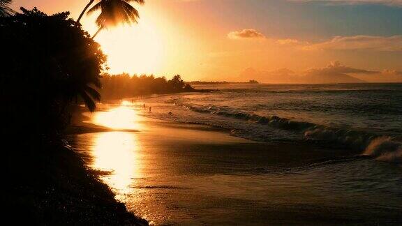橙色夕阳下的海滩背景是剪影波击沙鸟瞰图帕皮提法属波利尼西亚