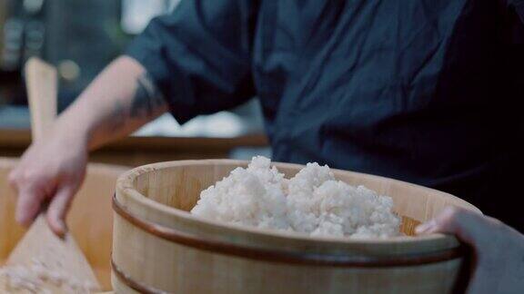 日本寿司厨师在木碗里制作寿司饭