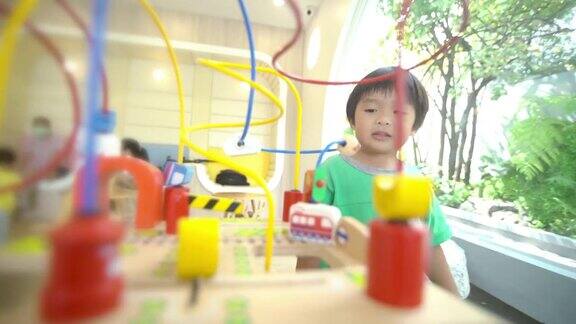 蹒跚学步的男孩在游戏室里玩算盘学习数学玩具