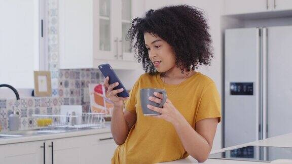 一个年轻女人在厨房用手机的照片