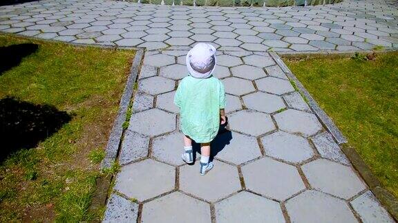 小男孩走在公园小路上后视镜