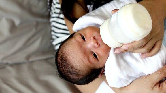 母亲用奶瓶喂养新生儿