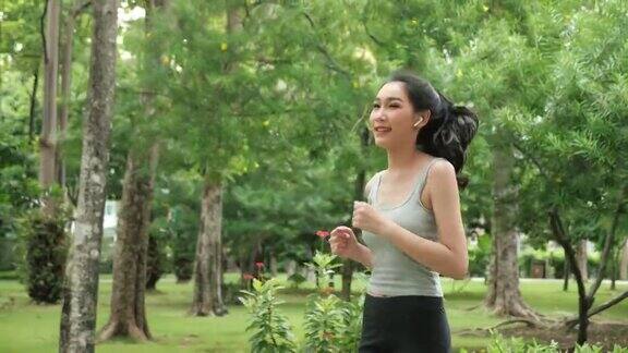快乐的亚洲女人在公园里跑步健康的生活方式