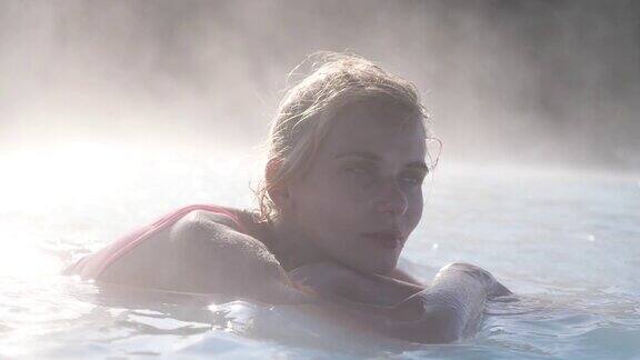 美丽的女子在冰岛的温泉池中放松