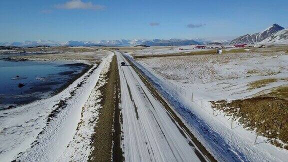 在冰岛东海岸的冬季飞过冰雪覆盖的道路和雪山景观