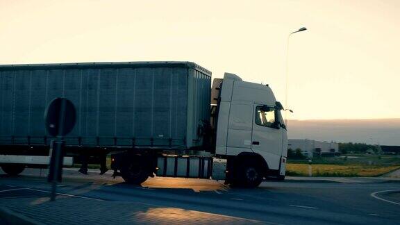 一辆带拖车的半卡车在高速公路上行驶的后续镜头清晨白色卡车驶过工业仓库