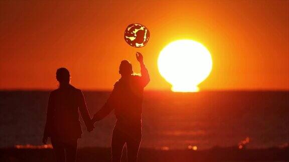 日落时分一对情侣在海滩上散步