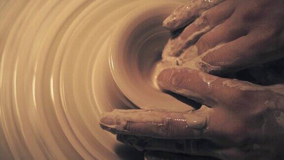 在陶轮上工作的女人的手制作一个陶瓷壶