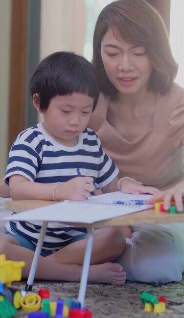 一个亚洲男孩和他妈妈一起做作业