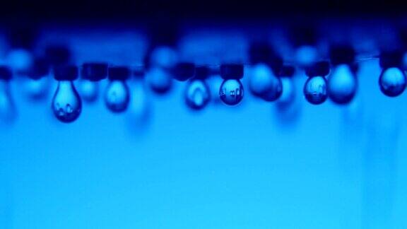 在一个现代的蓝色浴室里闪亮的水滴从金属喷雾器中流出
