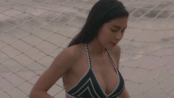 在海滩吊床上度假的亚洲女人