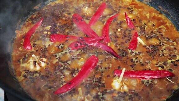 乌兹别克民族菜肴肉饭肉饭plov米饭和肉放在大锅里煮至沸腾在大锅中烧红辣椒和整个大蒜
