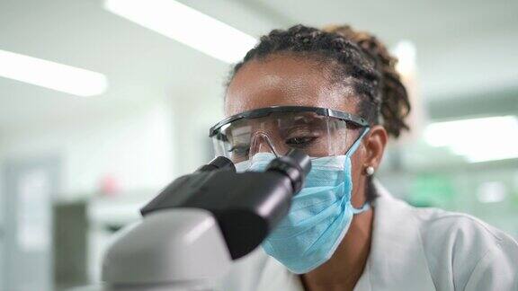 在实验室里找显微镜的女人戴着口罩