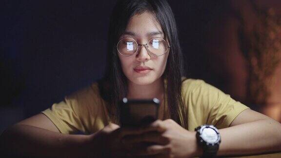 亚洲女性晚上在家使用智能手机