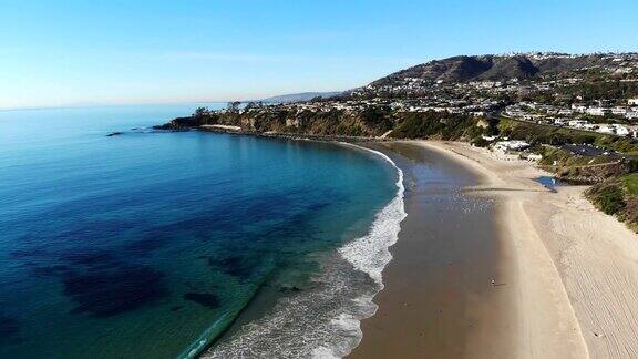 空中海滩视图无人机拍摄从沙滩草水晶清澈的水和悬崖在拉古纳盐溪海滩橘子县加州