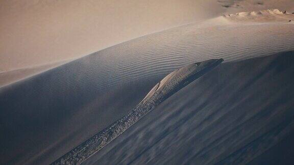 在午后温暖的阳光下大范围的沙尘暴吹过沙漠沙丘