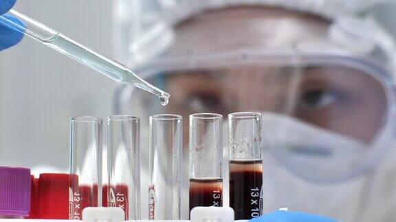 科学家在实验室将液体从移液管转移到血液试管中
