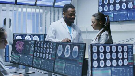 脑研究实验室的医学科学家讨论神经生理学计划的进展神经科学家被显示MRICT大脑扫描图像的屏幕包围