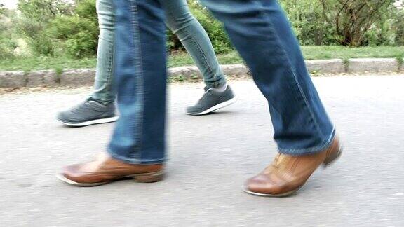 女人的脚在人行道上穿着鞋和运动鞋