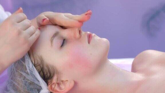 美容师将面霜涂抹于客户女性面部按摩皮肤