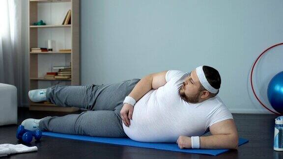 肥胖男性抬腿躺在垫子上健康生活方式运动休闲锻炼身体