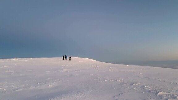 冬天登山者在高海拔的山峰上行走