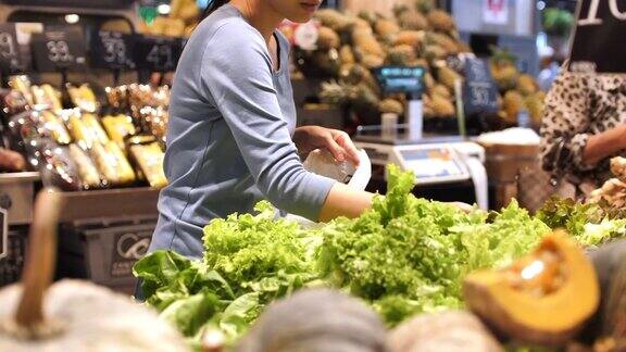 年轻女子在买新鲜蔬菜