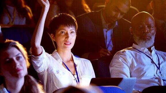 在4k大礼堂的商业研讨会上年轻的亚洲女商人举手