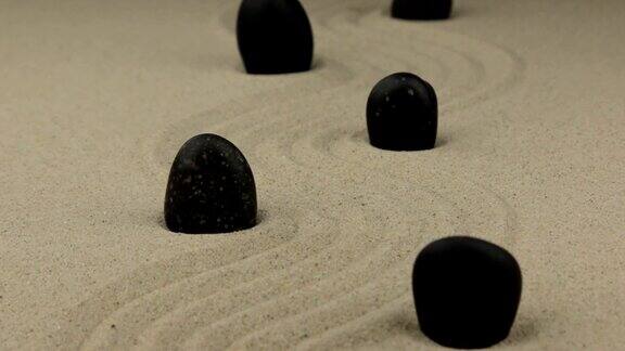 放大黑色的石头歪歪扭扭地躺在沙地上