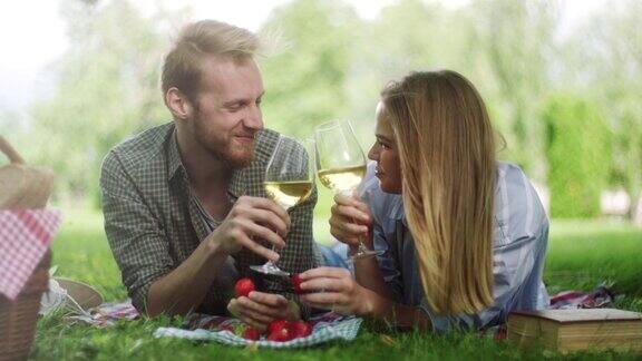 在野外野餐时男人给女朋友喂草莓