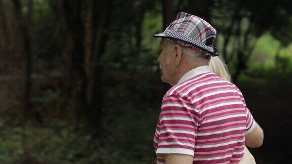 一对老年白种夫妇在公园里拥抱老人和女人走在一起丈夫妻子