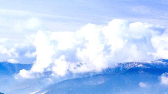 冬天的风景雾在冬天的山上移动天空是蓝色的