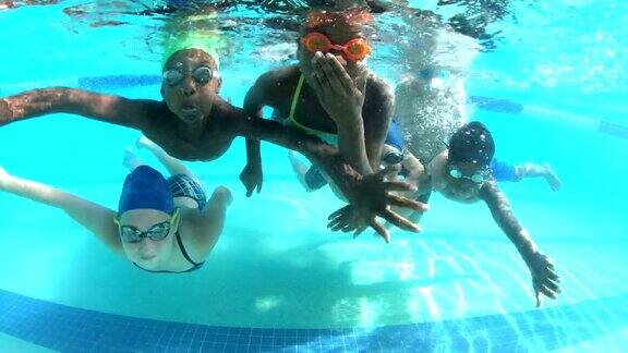 多民族儿童在水下挥舞着相机
