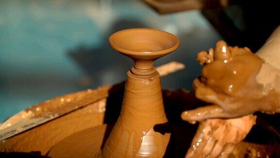 创造覆盖了一个陶罐靠近的手在陶工的轮子上工作粘土