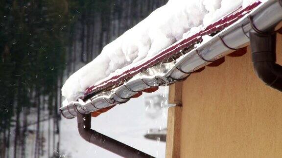雪在融化从屋顶上滴落下来